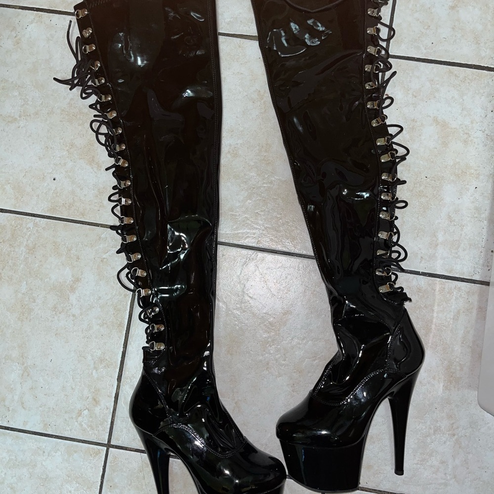 Pleaser black shiny leather thigh high boots lace up feature on back of the leg.